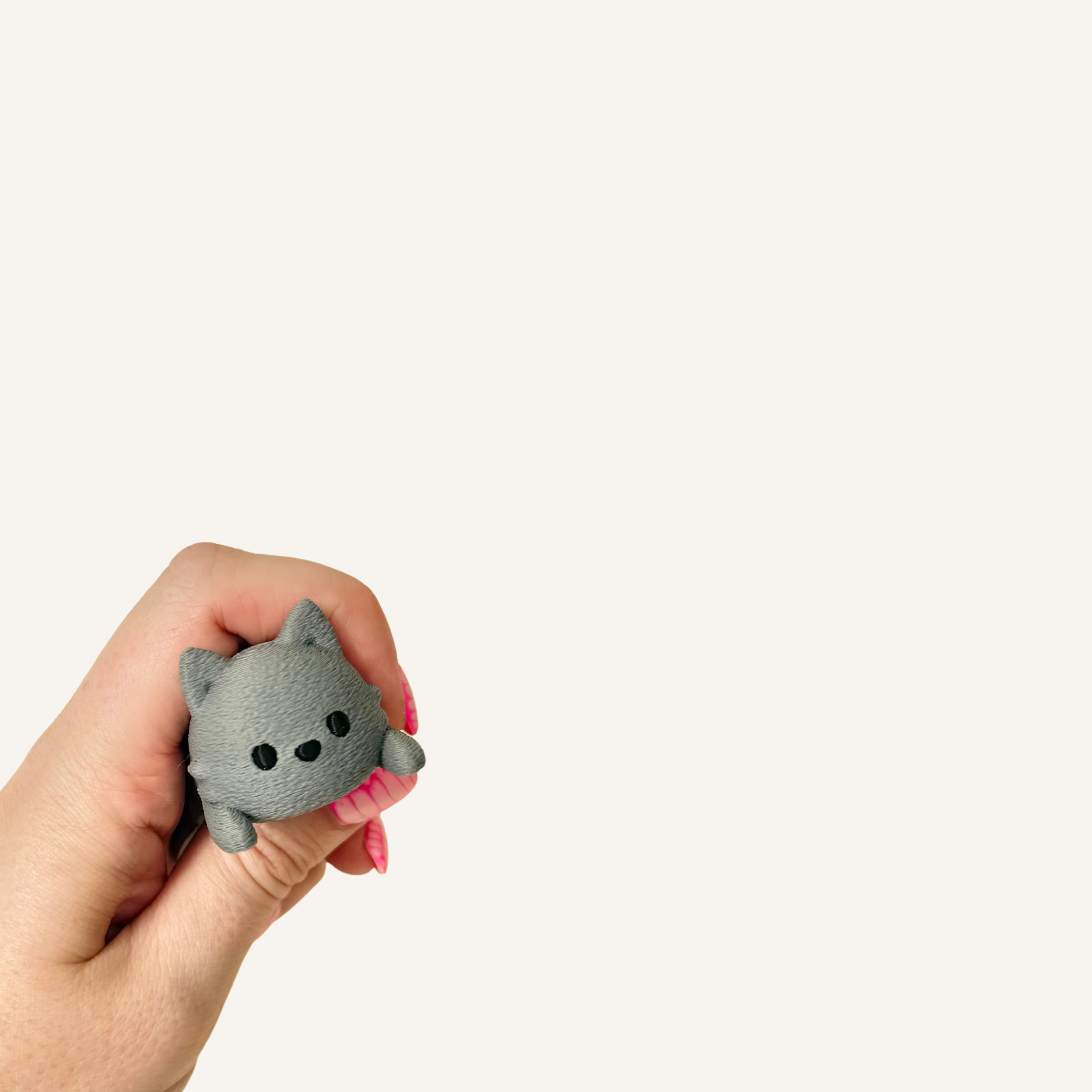 Pocket-sized spring cat with a textured finish for quiet tactile fidgeting.