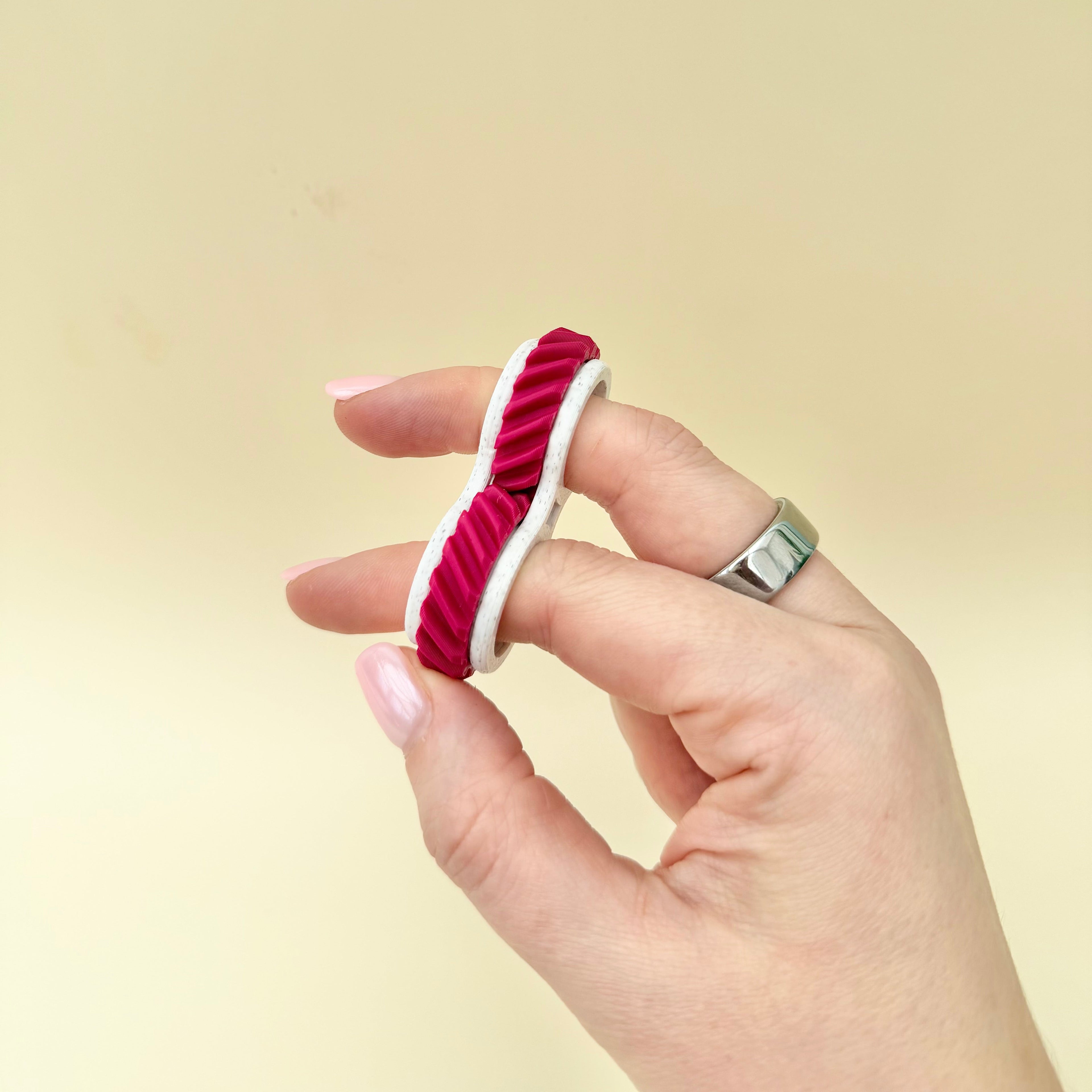 Discreet finger fidget with gentle rolling motion, textured feedback and low-noise movement for work or school.