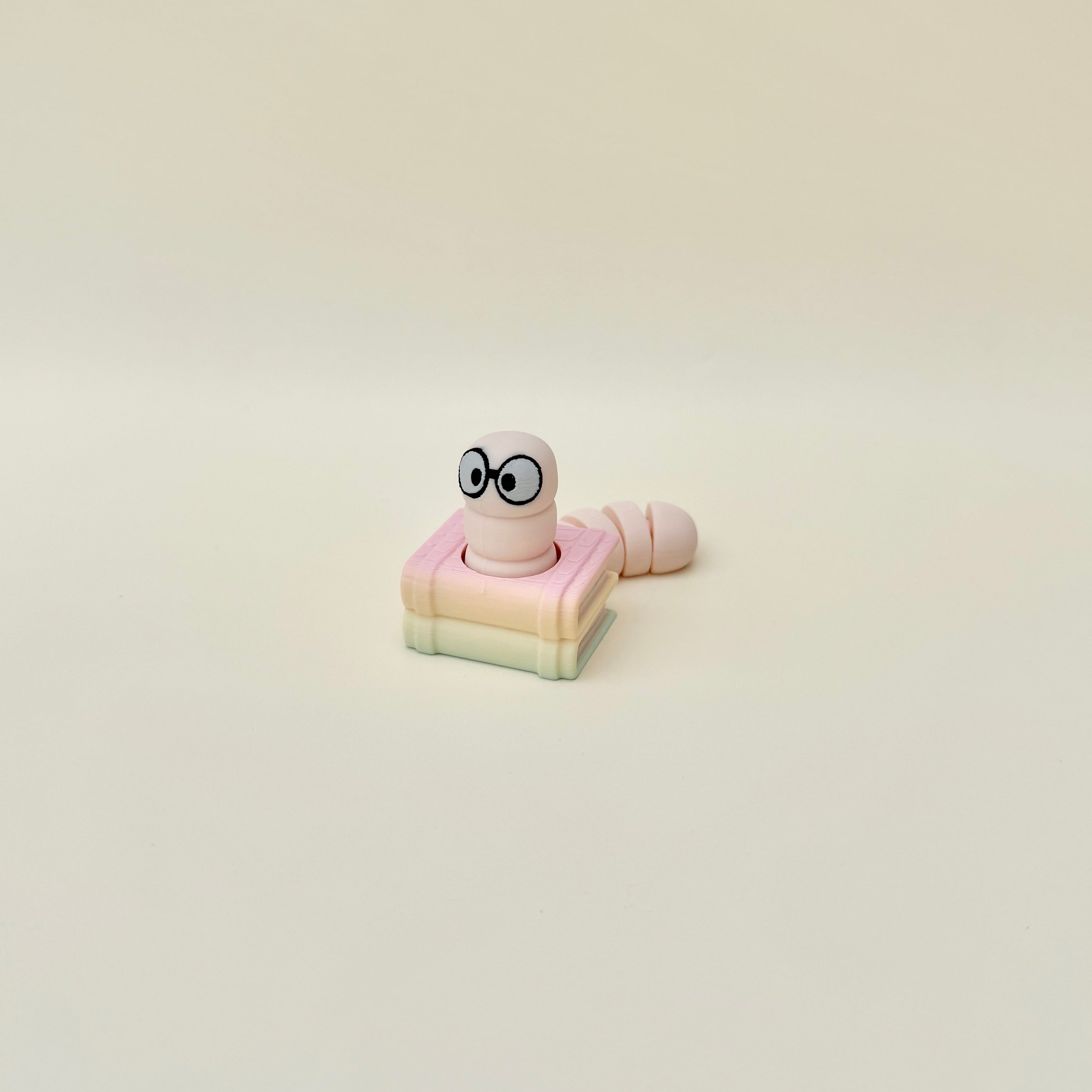 Book-themed clicker fidget with articulated tail and subtle colour variation, ideal for neurodivergent sensory needs.
