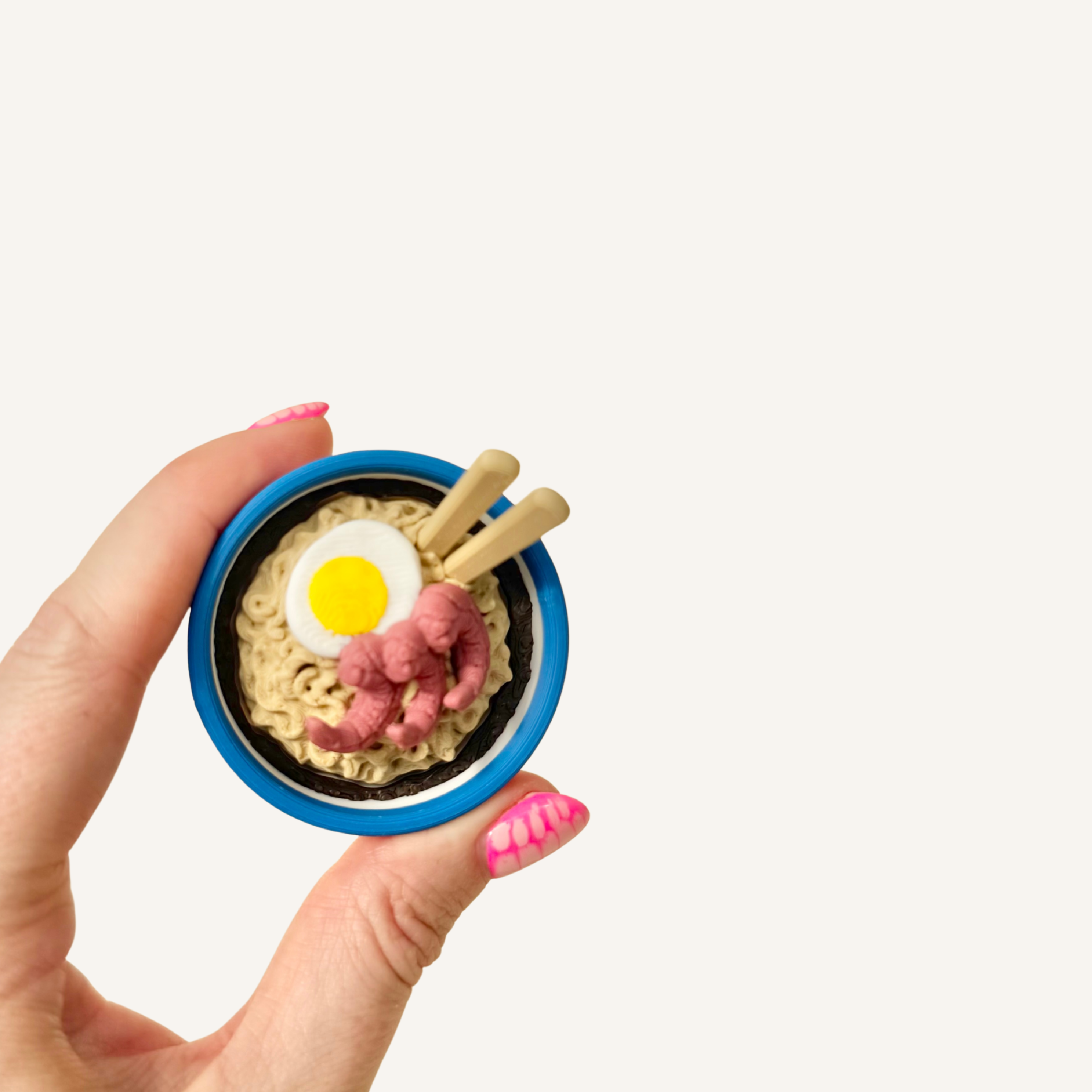 Miniature ramen bowl clicker with realistic noodles, prawns, egg and chopsticks.