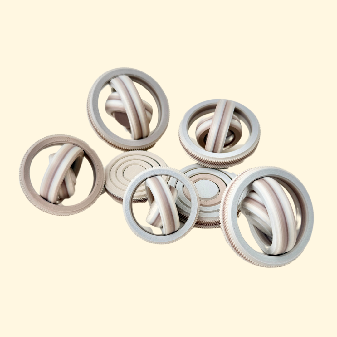 A neutral-toned fidget spinner featuring textured edges and a 4-gyro spinning design for sensory engagement.