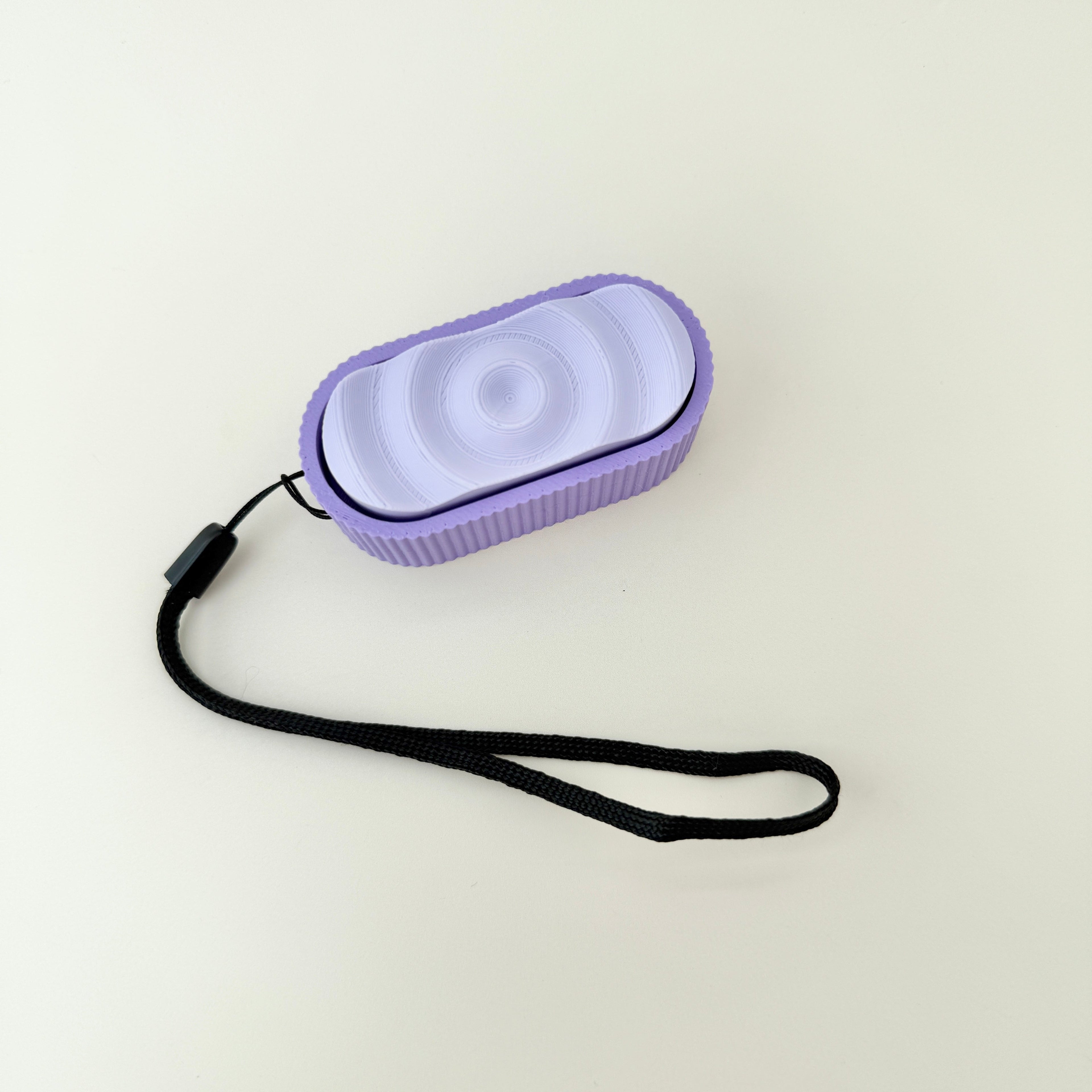 Ripple Click fidget toy with three clicker zones and textured design in lilac and purple.