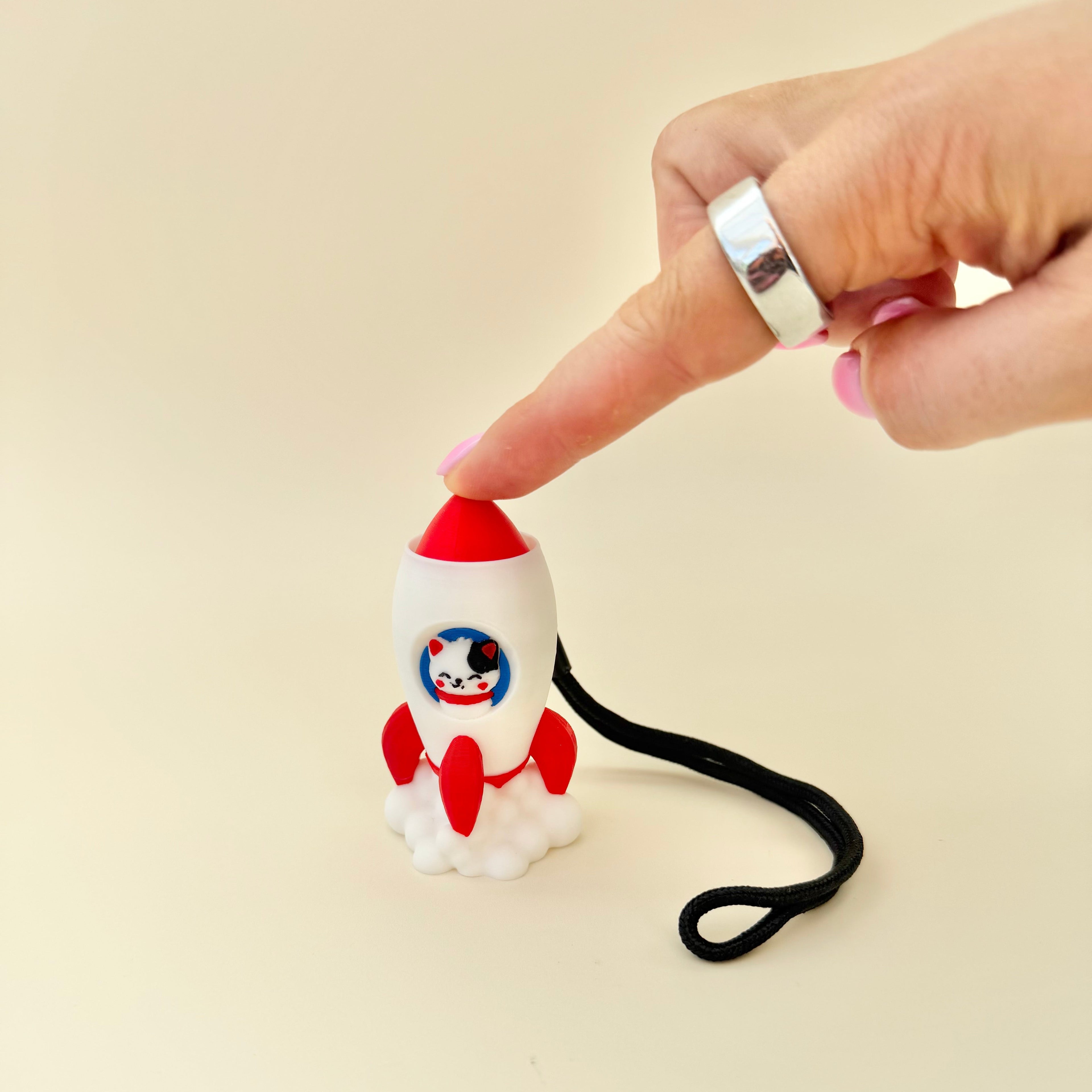 Space-themed clicker fidget with wrist strap, tactile details and everyday sensory use.