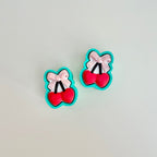 Press-to-click fidget with glossy bow accent and playful cherry motif, great for anxiety relief and busy hands.
