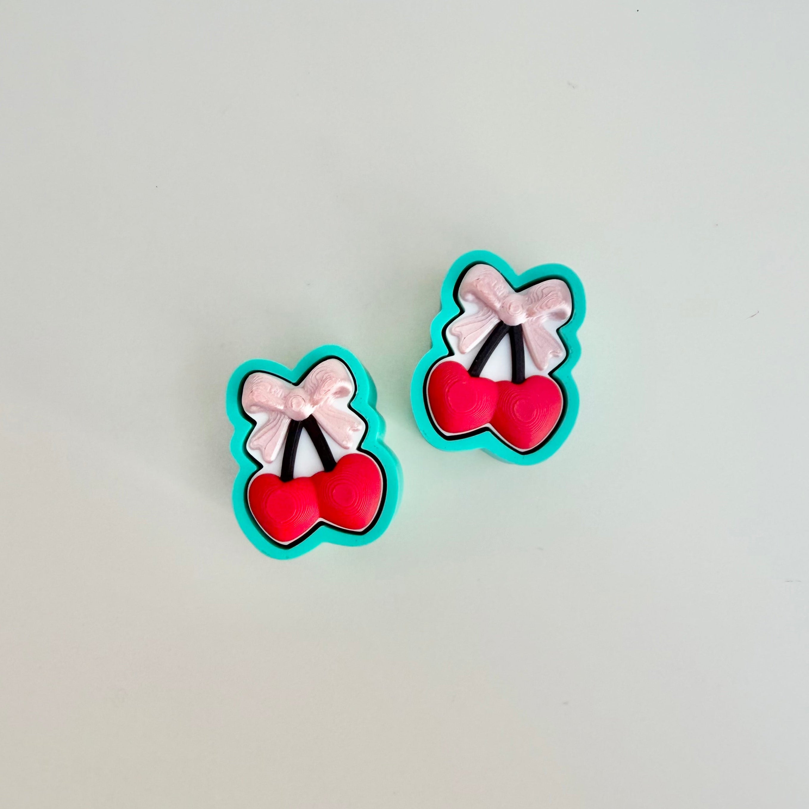 Press-to-click fidget with glossy bow accent and playful cherry motif, great for anxiety relief and busy hands.

