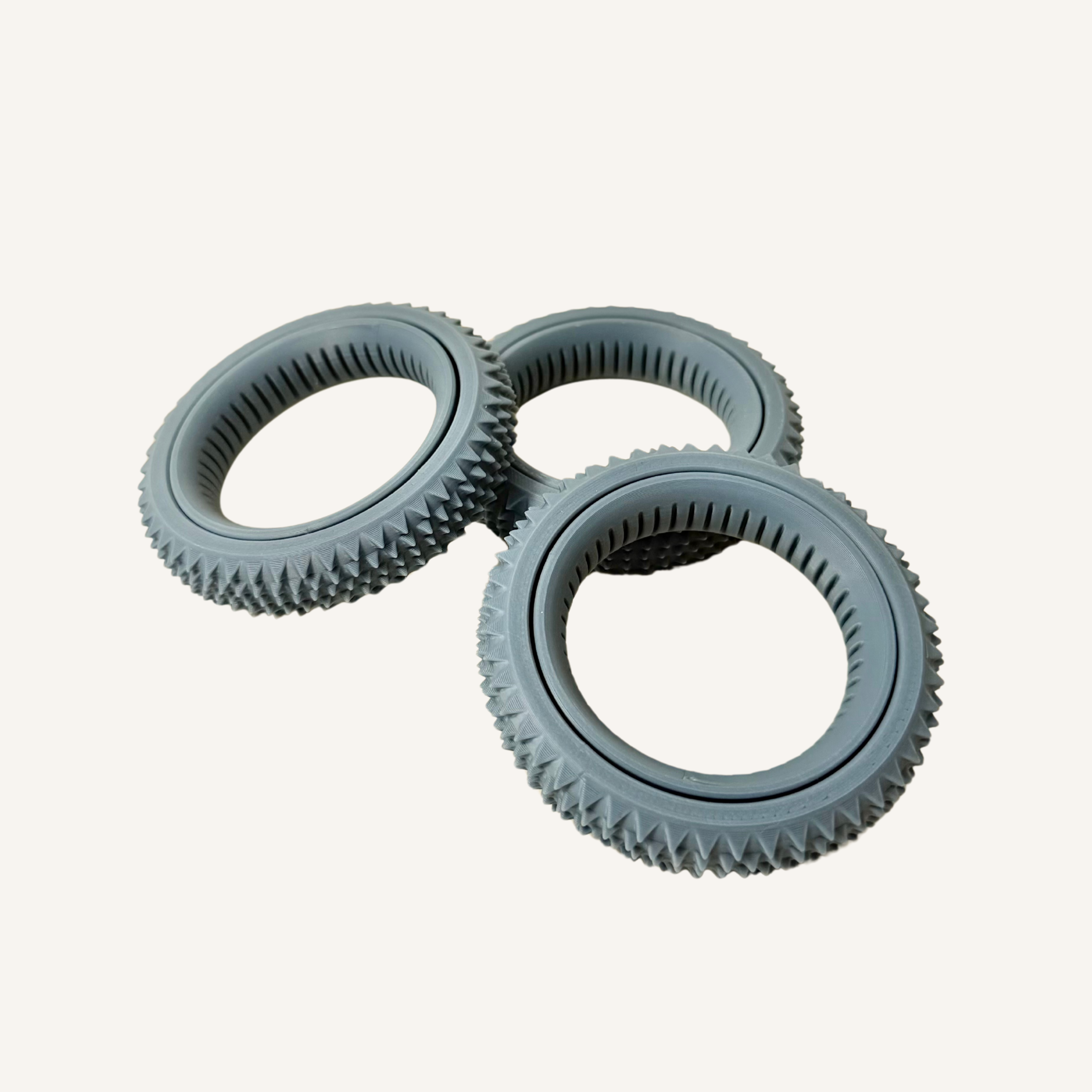 Grey sensory roller with spinning centre ring and textured outer surface for sensory input.