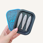 Tin-style sensory fidget with removable lid and three textured sardine clickers for tactile, playful desk stimming.
