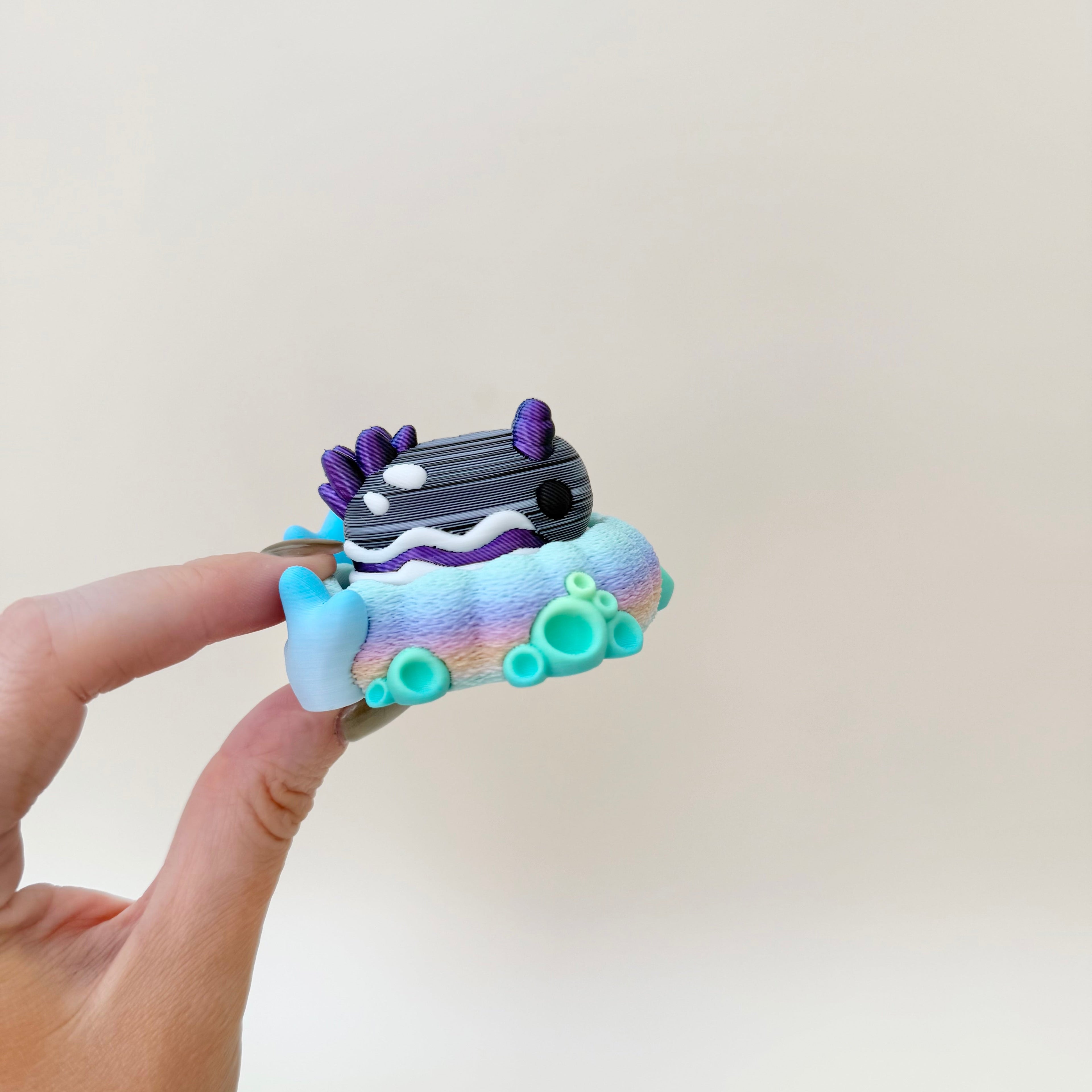 Small sea creature-inspired sensory fidget with adorable details and a bright pastel coral setting.
