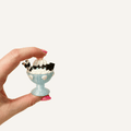 Miniature ice cream sundae clicker with whipped cream, chocolate drizzle and wafer sticks.