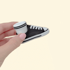 Handheld sneaker-style clicker fidget designed for repetitive pressing and sensory input.
