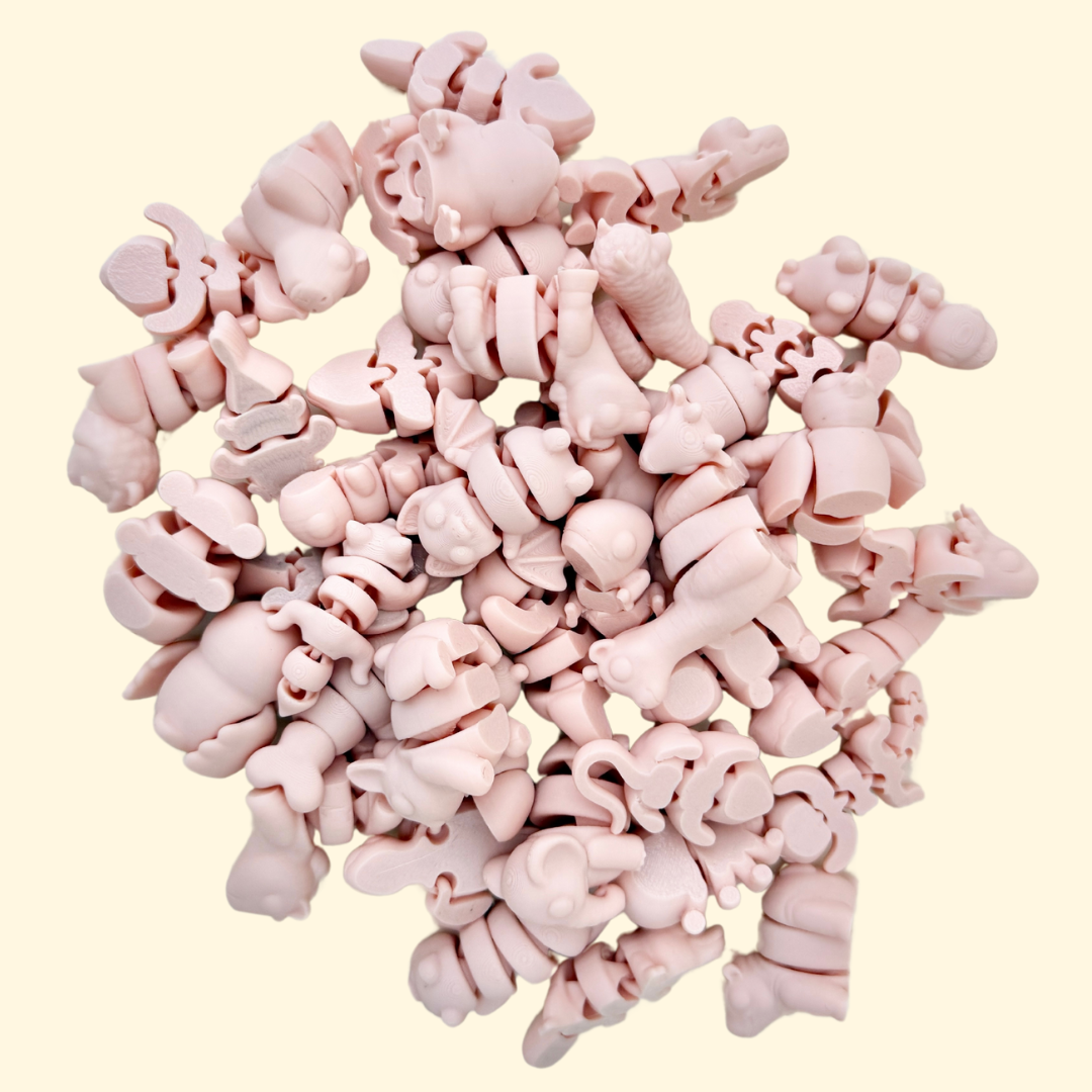 A selection of SoftTone Mini Pets in a silky, muted peachy-pink colour, fully articulated for sensory fidgeting.