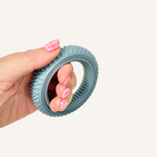Circular sensory fidget with rotating inner ring and textured outer edge for pressure feedback.