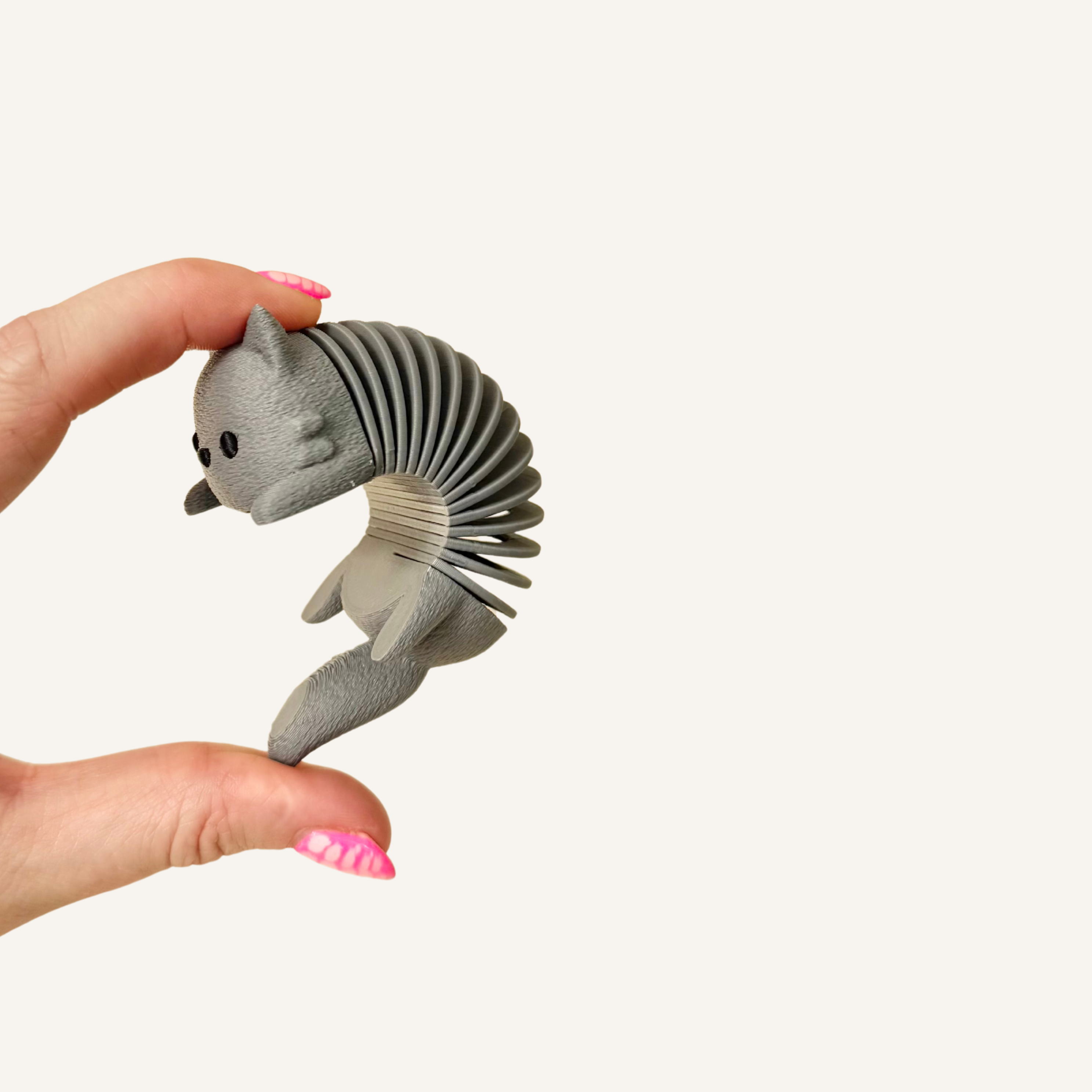 Quiet cat fidget with a flexible spring body and tactile textured finish.