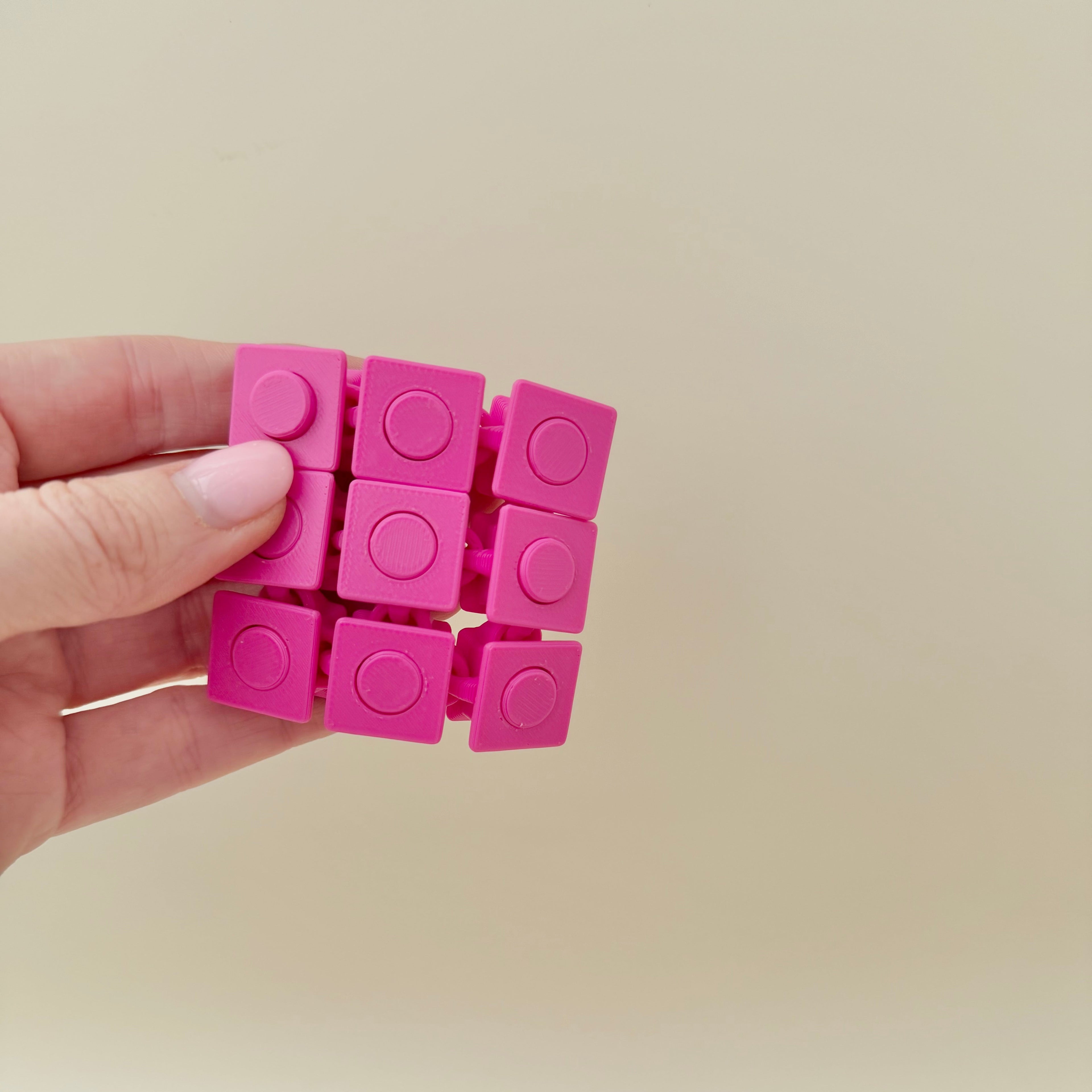 Tactile sensory toy with pop-through buttons that press from both sides.
