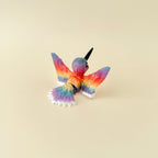 A beautifully detailed hummingbird fidget with white, red, and rainbow accents.