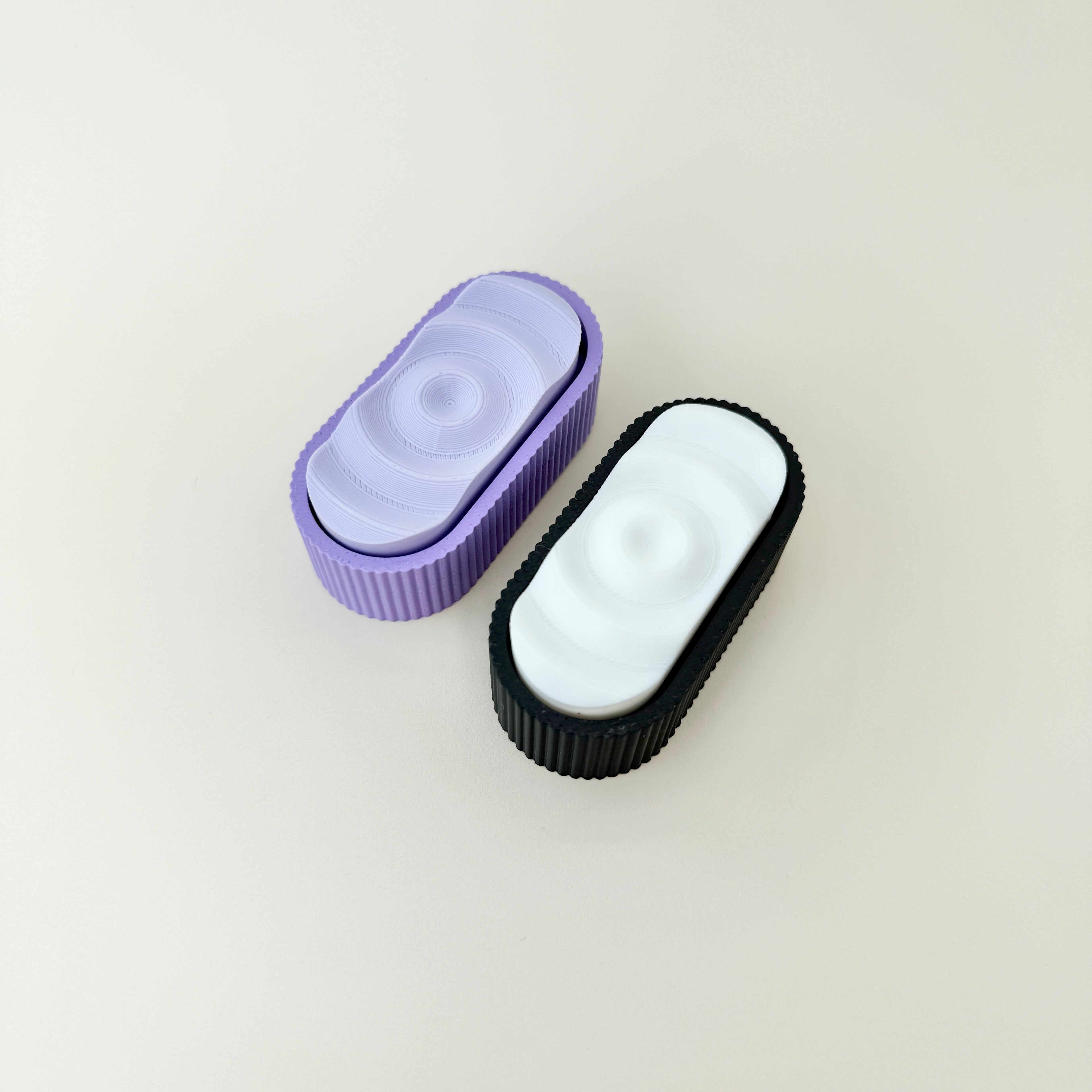 Triple-click fidget with ripple texture on top and textured grip around the edge.