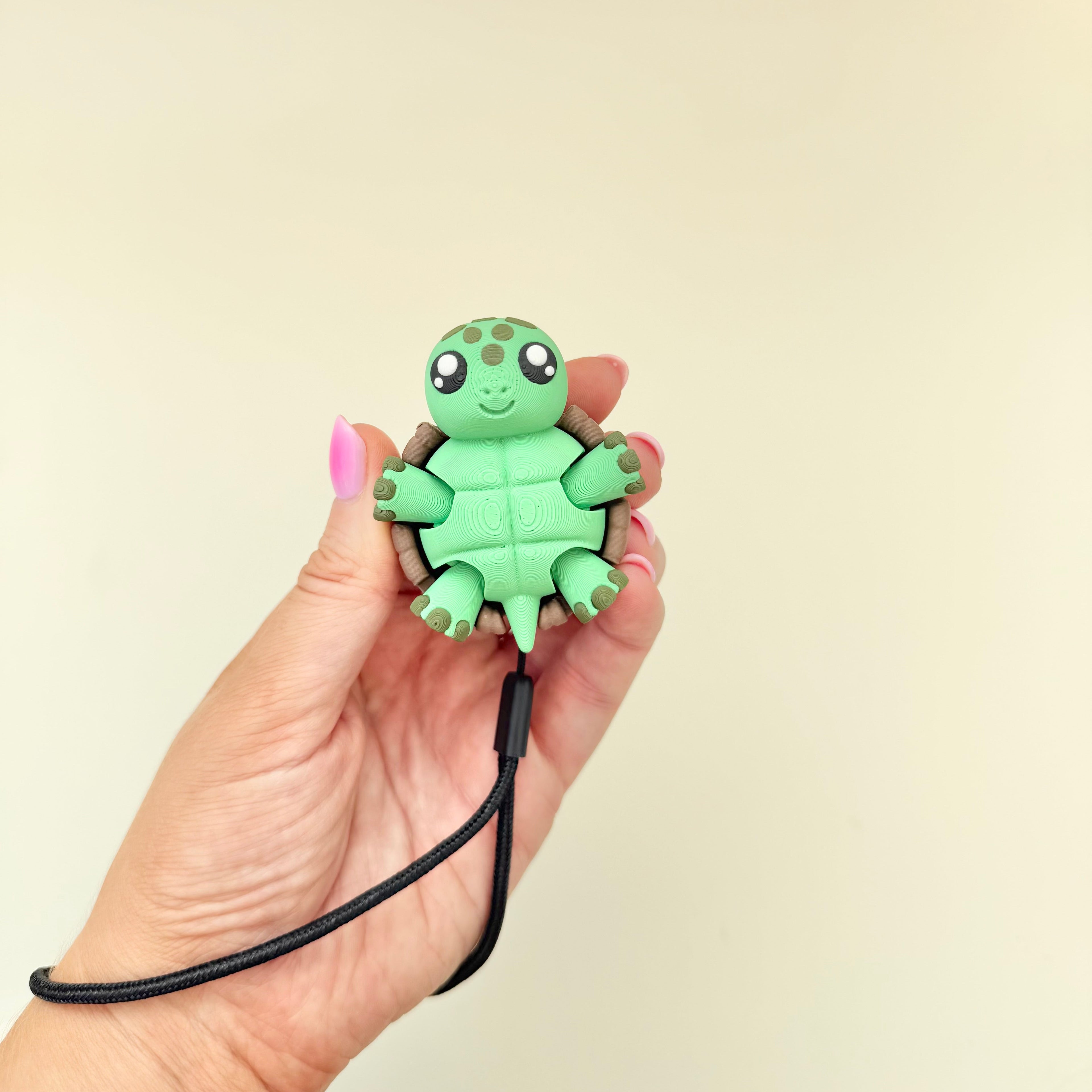 Small turtle fidget with wrist strap, tactile shell details and carry-along sensory support.
