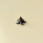 A tactile fidget toy featuring gradient colours in grey, white, brown, and blue with a bold, spiked design.