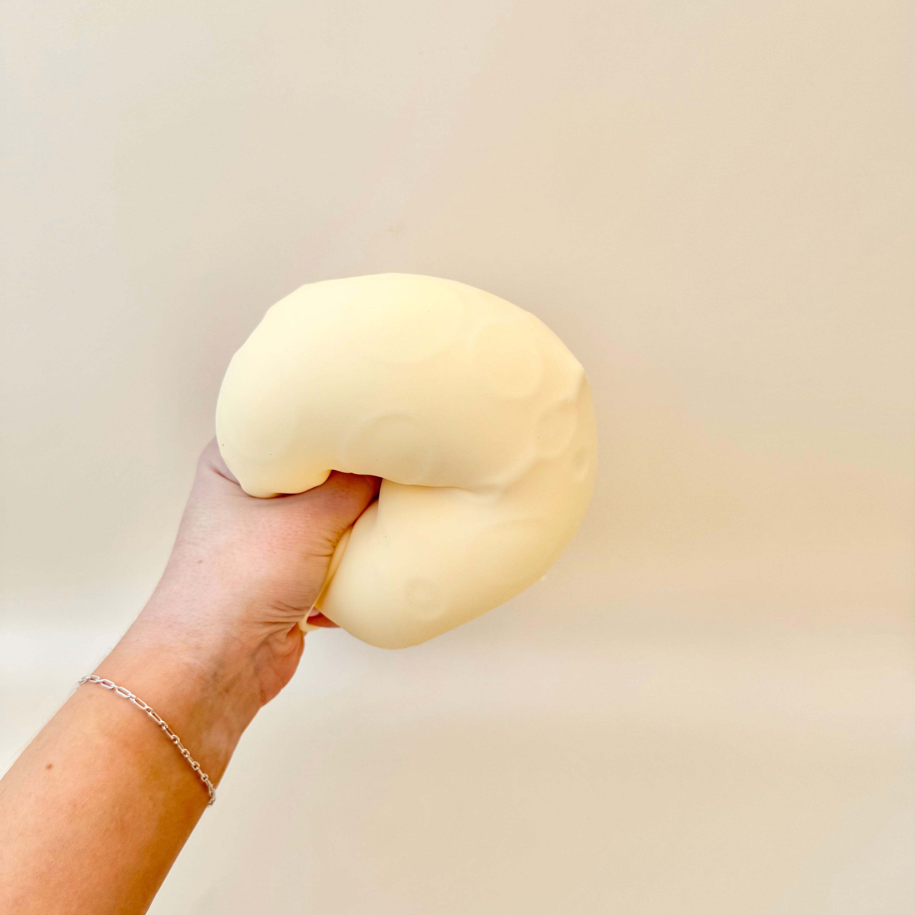 Two size options of a gel-filled cheese squish toy with different finishes for sensory squeezing