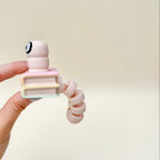 Small bookworm sensory fidget combining a press clicker and flexible tail movement for busy hands and grounding.
