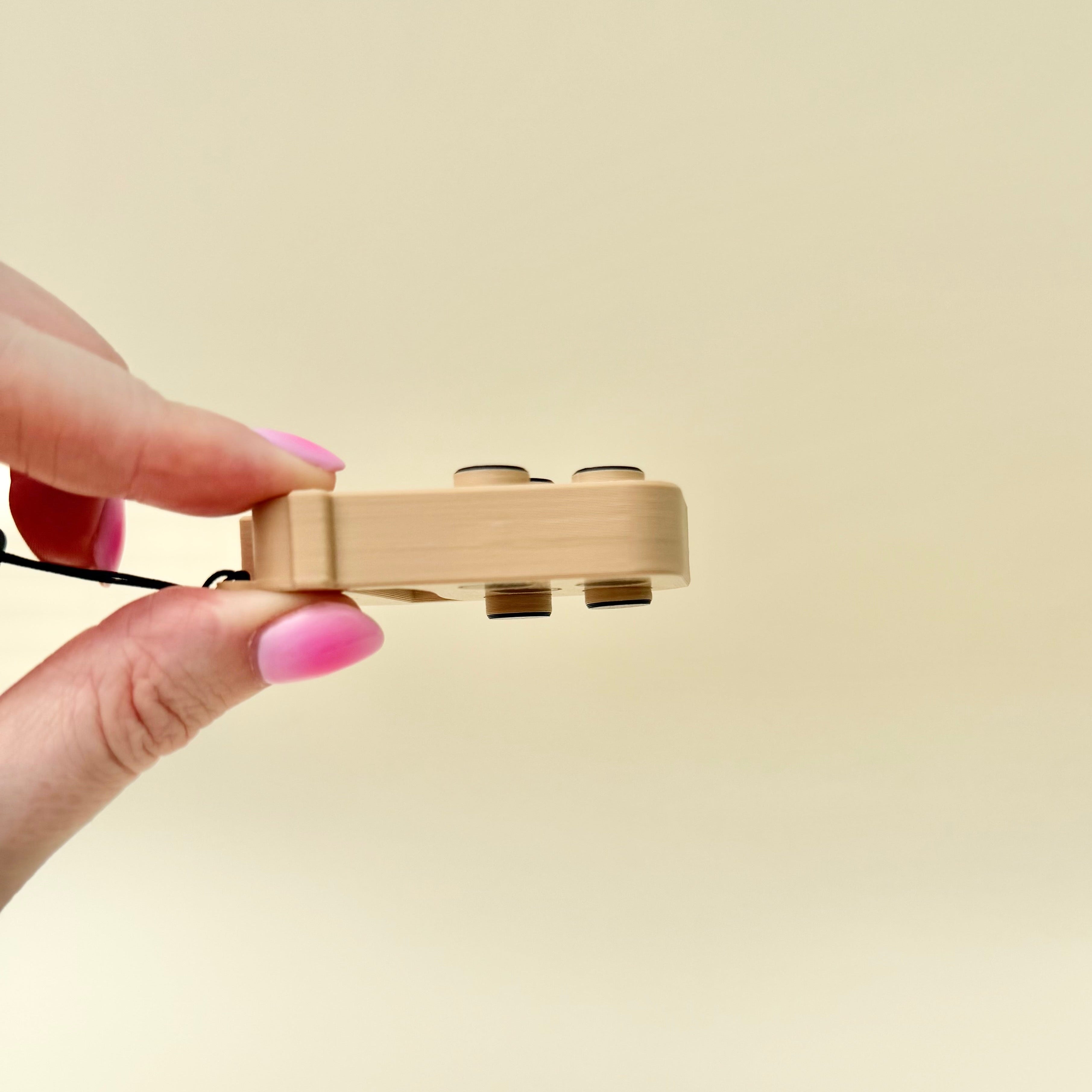 Portable pop fidget with wrist strap, bubble press action and neurodivergent-friendly sensory support.