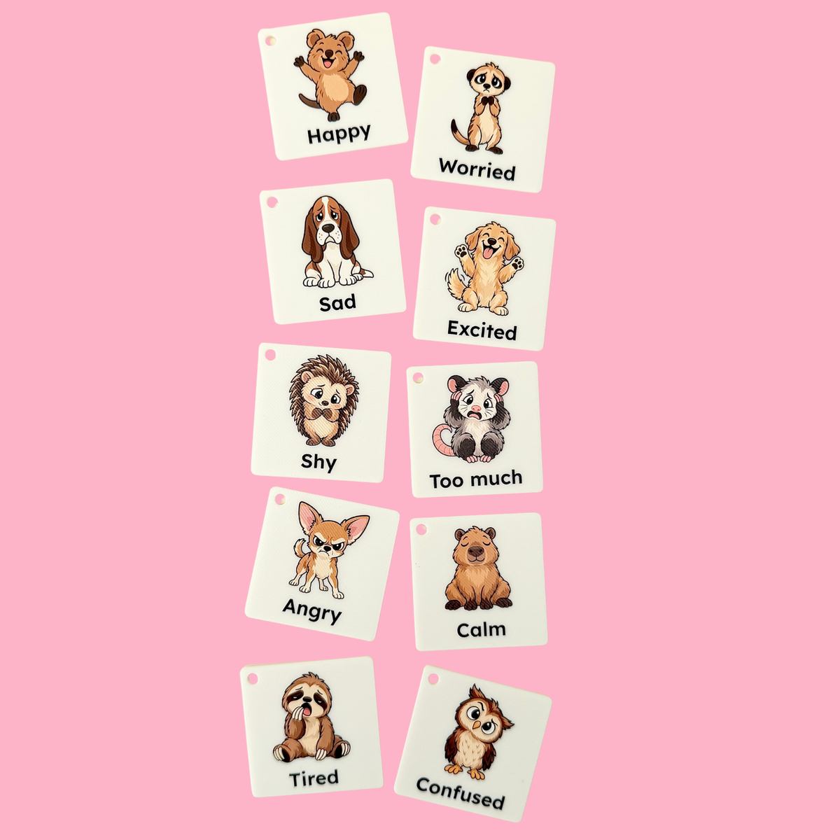 Hand holding Animal Feelings COMMZ tiles showing the portable 45mm communication tile size.