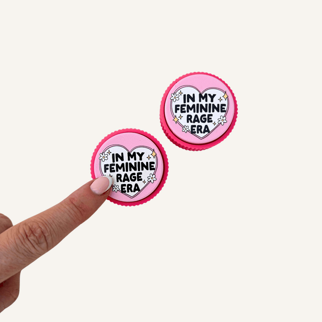 Feminine Rage sensory clicker with hot pink ridged base, pale pink top and raised tactile artwork.