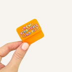 Pocket-sized magnetic sensory fidget held in one hand for repetitive sliding and snapping movement.