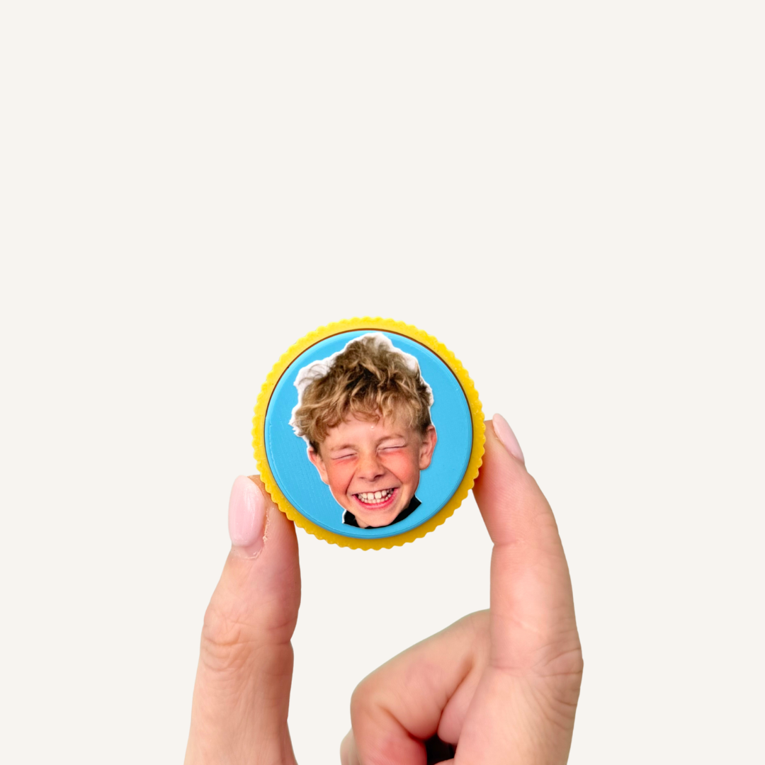 Round personalised photo clicker with custom colour choices and a satisfying press-down clicking mechanism.