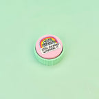 Pink and mint handheld sensory clicker with tactile outer ridges and raised colourful artwork.