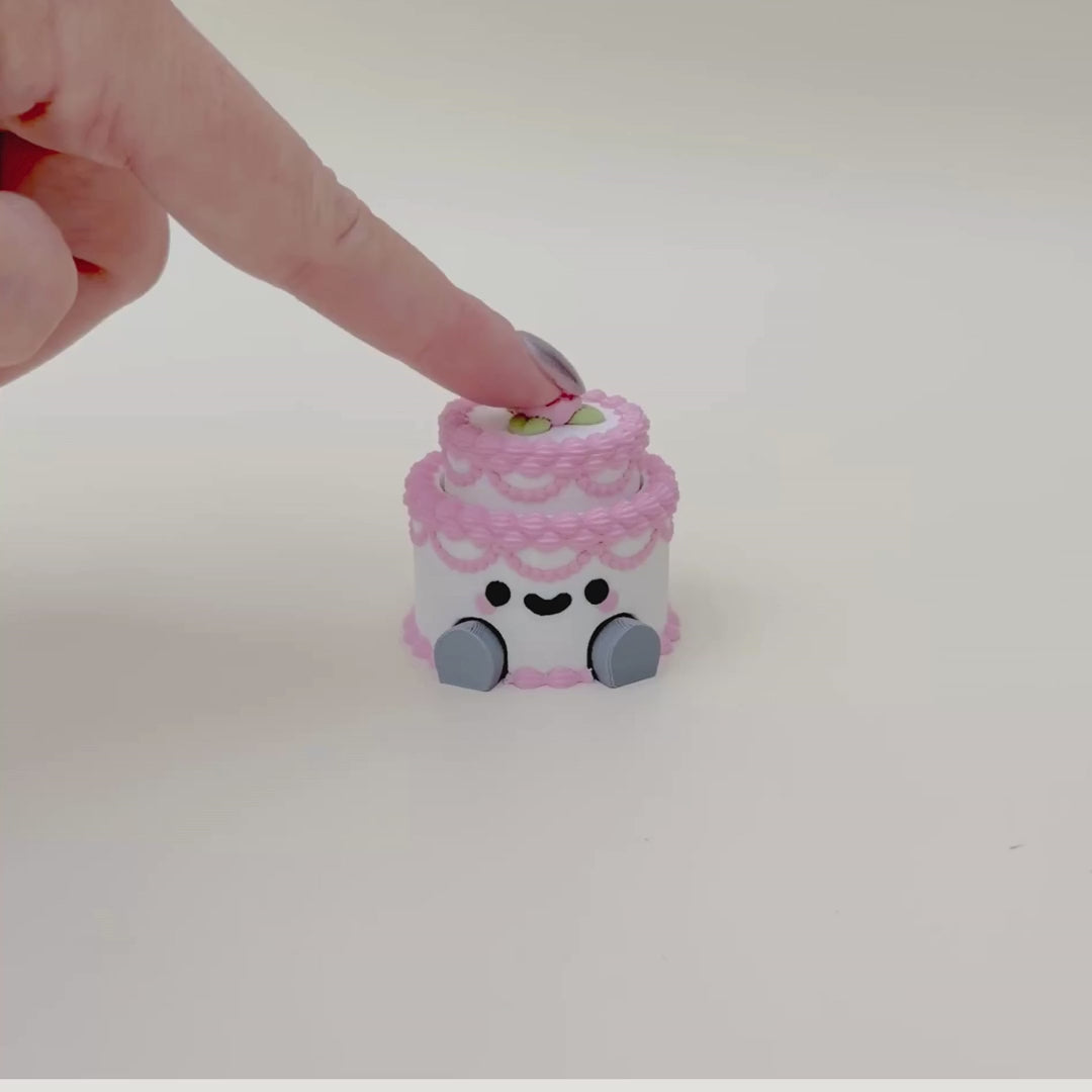 Handheld sensory clicker with a detailed layered design, dangling legs, and optional quieter click feel.

