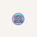 Pink and blue Smutty Book Club sensory clicker with ridged outer edge and raised tactile artwork.
