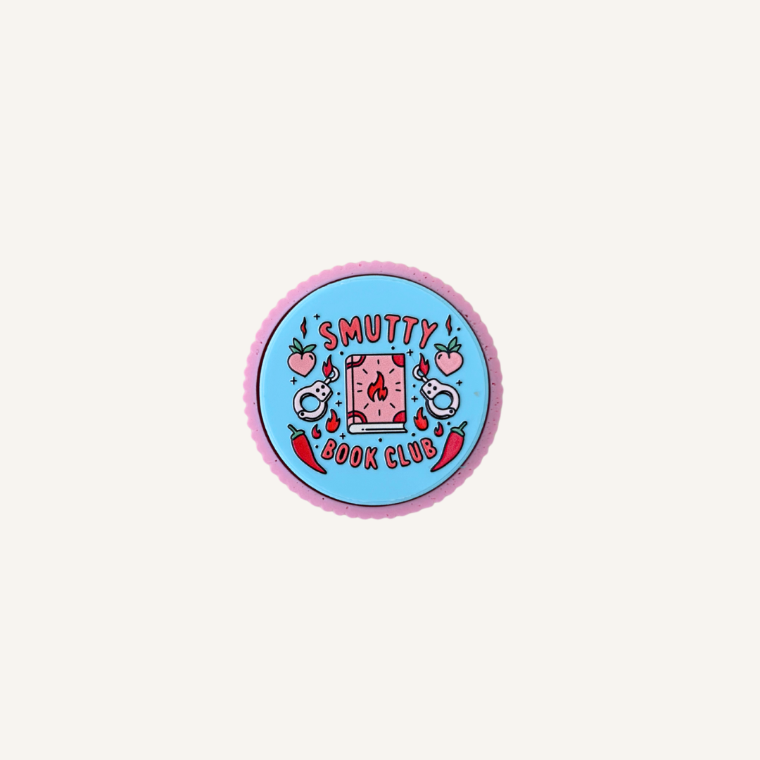 Pink and blue Smutty Book Club sensory clicker with ridged outer edge and raised tactile artwork.
